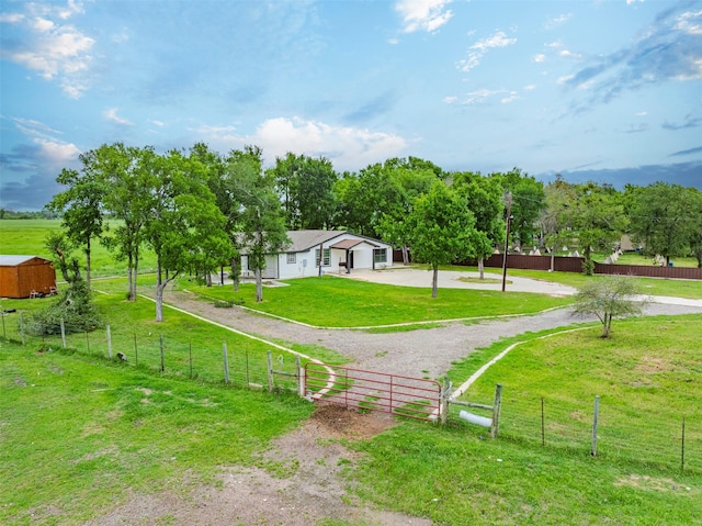 1189 Fm 935, Lott, TX 76656 - view of home's community featuring a garage, a lawn, fence, curved driveway, and a gate