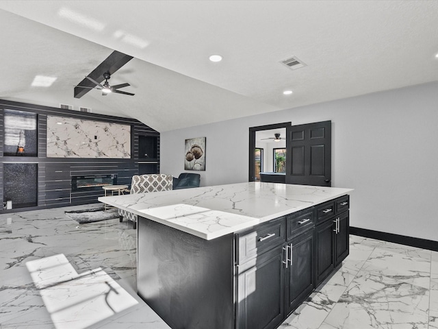 11506 Kirkhollow Dr, Houston, TX 77089 - kitchen with ceiling fan, dark cabinetry, light marble finish flooring, a center island, and vaulted ceiling