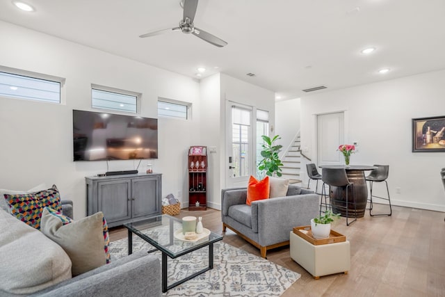 living room with recessed lighting, visible vents, light wood-type flooring, stairs, and ceiling fan