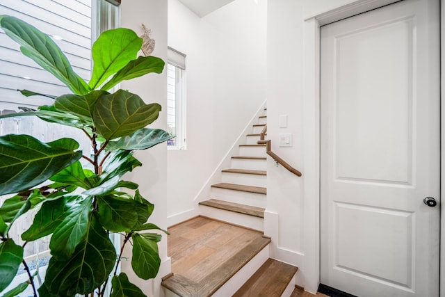 staircase with baseboards and wood finished floors