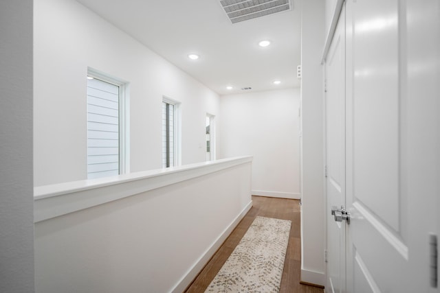 hall featuring recessed lighting, wood finished floors, visible vents, and baseboards