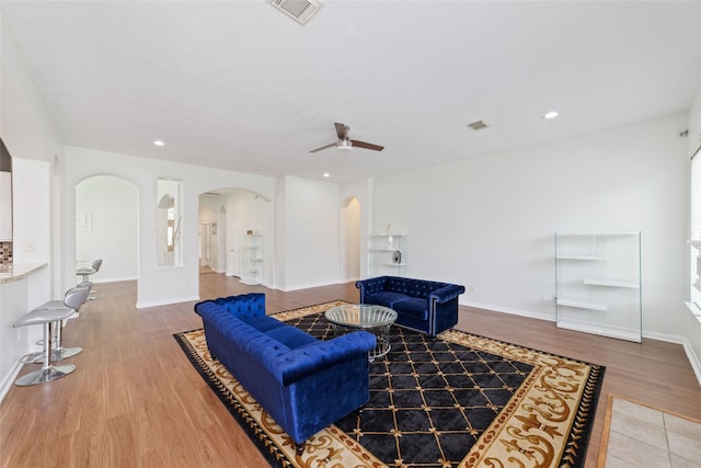 8122 Dune Brook Dr, Pearland, TX 77089 - living room with arched walkways, light wood finished floors, a ceiling fan, baseboards, and recessed lighting