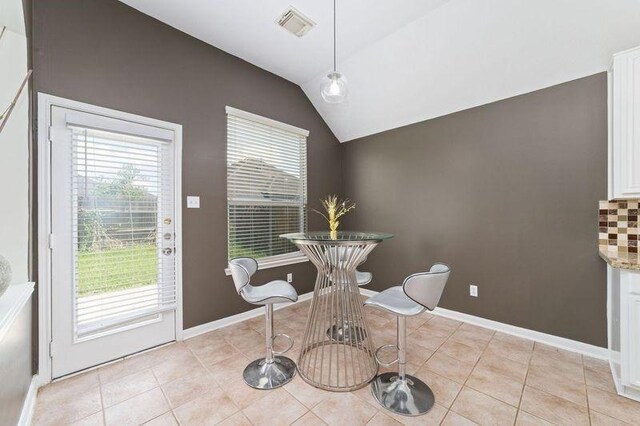 8122 Dune Brook Dr, Pearland, TX 77089 - dining space with healthy amount of natural light, lofted ceiling, light tile patterned flooring, and baseboards