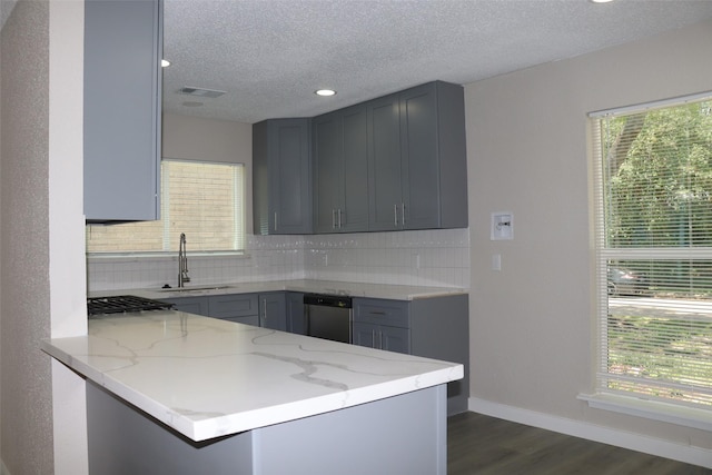 kitchen with a sink, gray cabinets, dishwasher, and light stone countertops