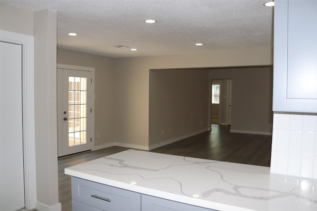 interior space with dark wood-type flooring, recessed lighting, and a textured ceiling