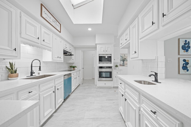 4731 N Cashel Cir, Houston, TX 77069 - kitchen with white cabinets, under cabinet range hood, a sink, and appliances with stainless steel finishes