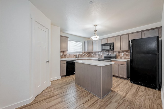 kitchen featuring light wood finished floors, a sink, black appliances, and backsplash