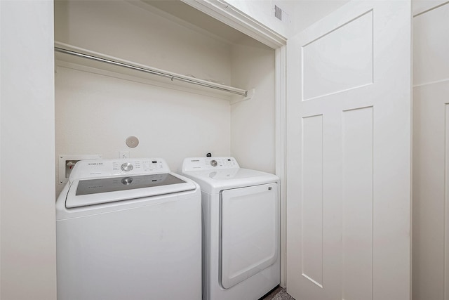 clothes washing area with laundry area, separate washer and dryer, and visible vents