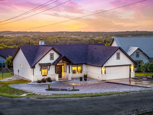 modern inspired farmhouse featuring a shingled roof, stone siding, a garage, and concrete driveway