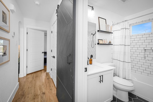 bathroom featuring visible vents, toilet, shower / bath combo with shower curtain, vanity, and wood finished floors