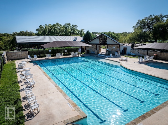community pool with fence and a patio