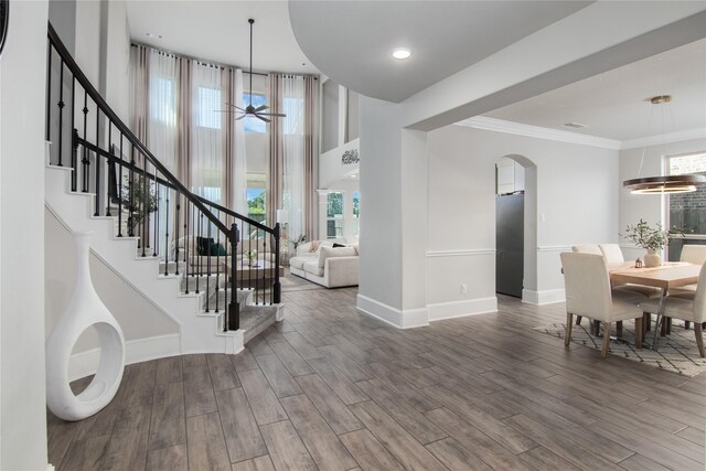 2736 Ahnya Ln, League City, TX 77573 - entryway featuring arched walkways, stairs, baseboards, wood finished floors, and ornamental molding