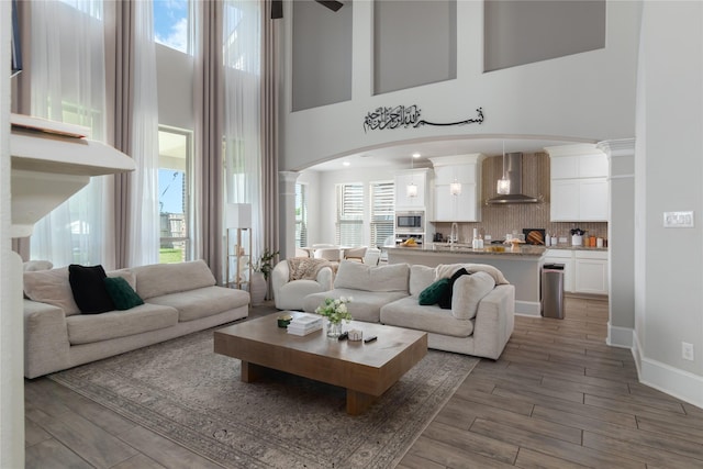 2736 Ahnya Ln, League City, TX 77573 - living room with a high ceiling, healthy amount of natural light, wood finished floors, and arched walkways