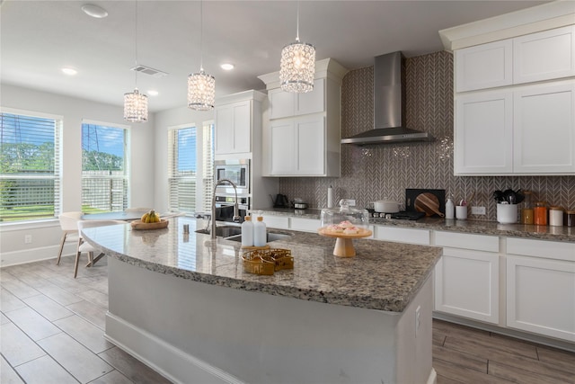 2736 Ahnya Ln, League City, TX 77573 - kitchen with wall chimney range hood, a chandelier, decorative backsplash, white cabinetry, and recessed lighting