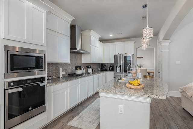 2736 Ahnya Ln, League City, TX 77573 - kitchen featuring stainless steel appliances, wall chimney range hood, a sink, dark wood-style floors, and recessed lighting