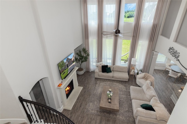 2736 Ahnya Ln, League City, TX 77573 - living area featuring a high ceiling, a warm lit fireplace, healthy amount of natural light, wood finished floors, and ceiling fan