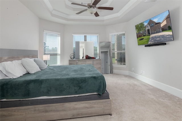 2736 Ahnya Ln, League City, TX 77573 - carpeted bedroom with multiple windows, ornamental molding, a tray ceiling, baseboards, and ceiling fan