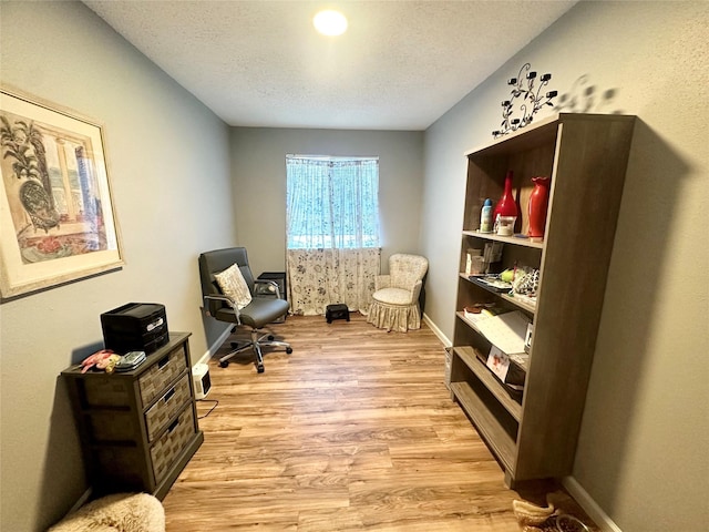 6452 Kentwick Dr, Houston, TX 77084 - home office featuring light wood-style flooring, baseboards, and a textured ceiling