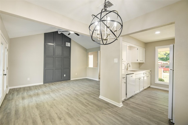 kitchen with a sink, light countertops, white appliances, white cabinetry, and light wood-style flooring