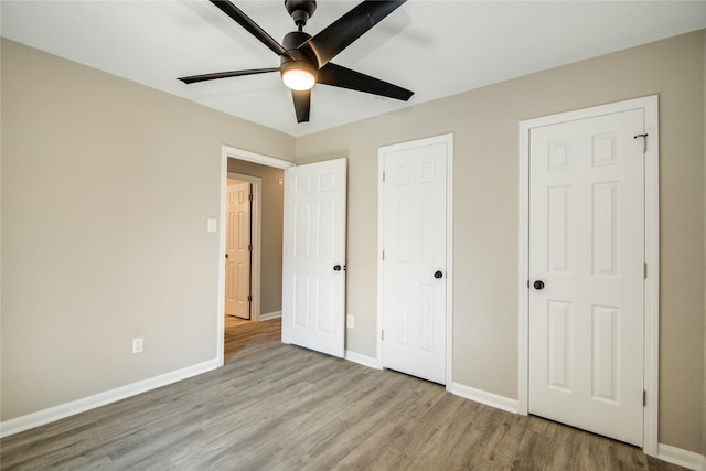 unfurnished bedroom with baseboards, a ceiling fan, and wood finished floors