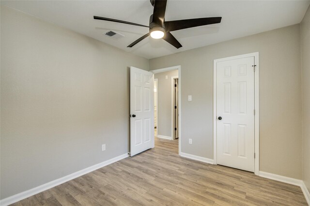 unfurnished bedroom featuring light wood finished floors, visible vents, and baseboards