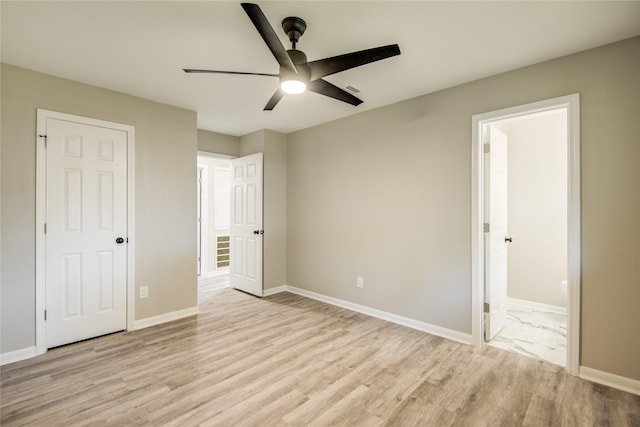 unfurnished bedroom with baseboards, light wood-type flooring, ceiling fan, and ensuite bath