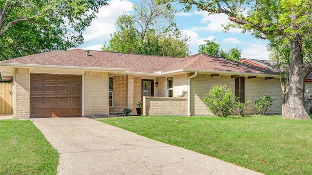 ranch-style house with a shingled roof, an attached garage, brick siding, a front lawn, and driveway