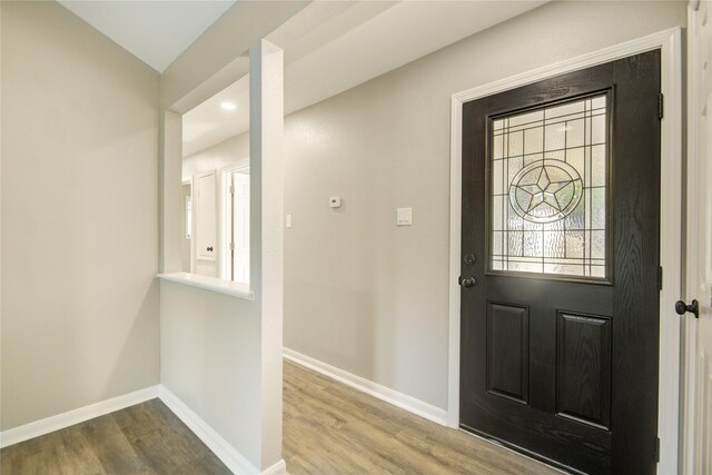 foyer entrance with wood finished floors and baseboards