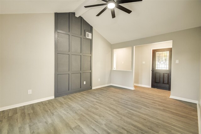 unfurnished living room with baseboards, a ceiling fan, visible vents, light wood finished floors, and vaulted ceiling with beams