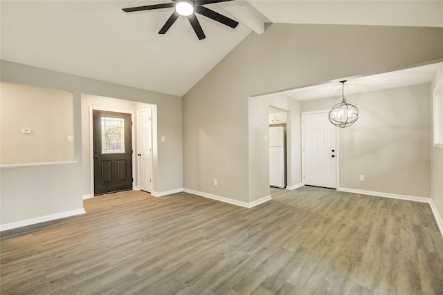 entrance foyer featuring ceiling fan with notable chandelier, wood finished floors, baseboards, and beam ceiling