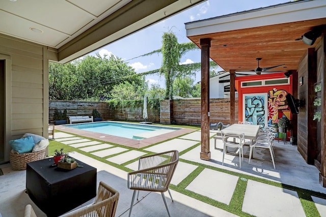 view of patio with a fenced backyard, outdoor dining space, a fenced in pool, and ceiling fan