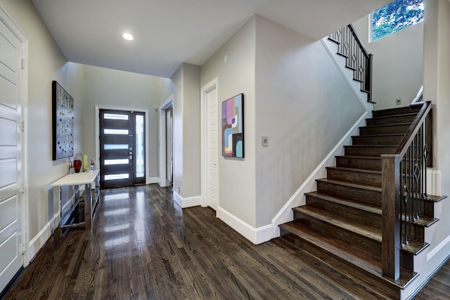 foyer featuring a healthy amount of sunlight, baseboards, dark wood finished floors, and stairway