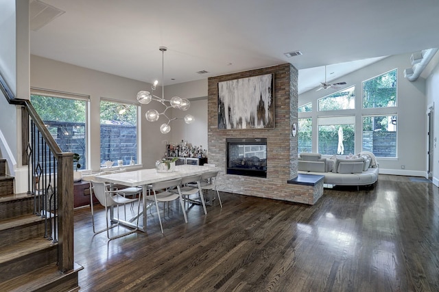 dining room with visible vents, dark wood finished floors, stairway, and a fireplace