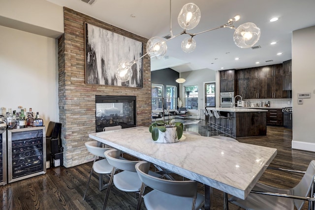 kitchen with light countertops, dark wood-style floors, dark brown cabinets, beverage cooler, and a breakfast bar area