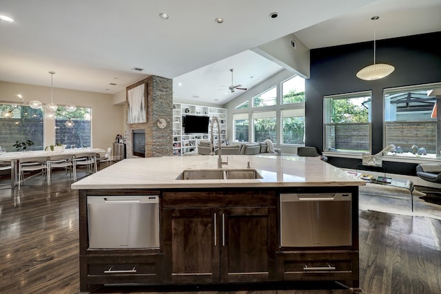 kitchen with a sink, open floor plan, stainless steel dishwasher, and dark wood finished floors