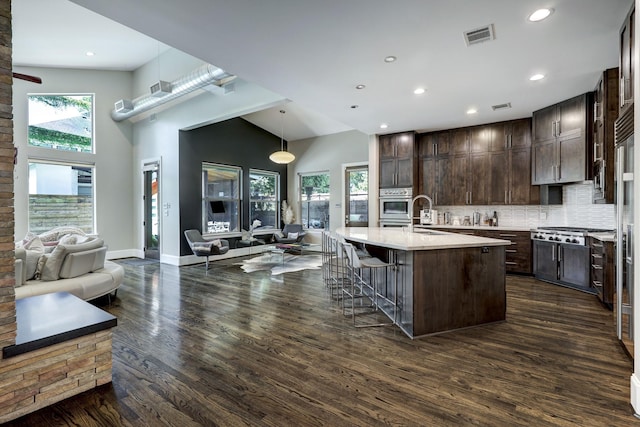 kitchen featuring dark brown cabinetry, dark wood-type flooring, visible vents, recessed lighting, and backsplash