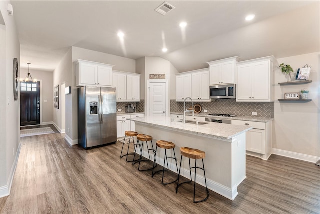 21718 Rose Maris Ln, Tomball, TX 77377 - kitchen featuring tasteful backsplash, visible vents, a sink, appliances with stainless steel finishes, and an island with sink