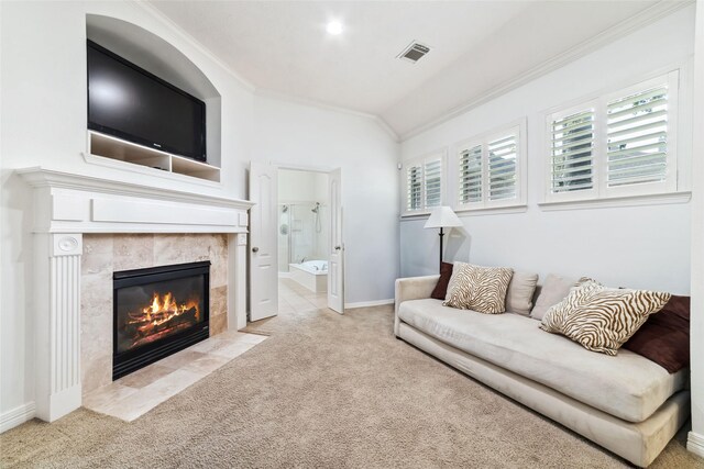 carpeted living area featuring visible vents, crown molding, a tile fireplace, baseboards, and lofted ceiling