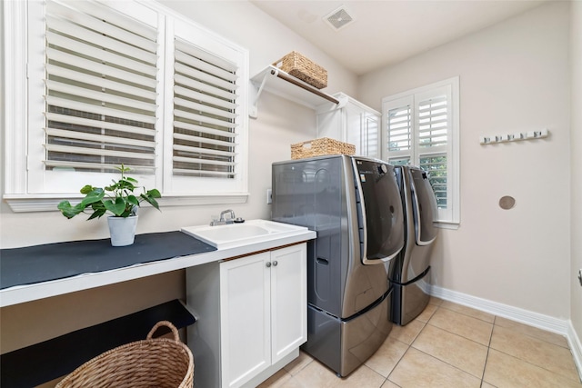 clothes washing area featuring a sink, washer and clothes dryer, cabinet space, and baseboards