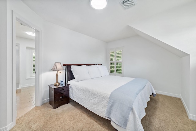 bedroom with visible vents, carpet flooring, baseboards, and vaulted ceiling