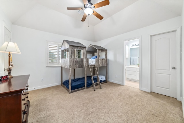 carpeted bedroom with baseboards, vaulted ceiling, ceiling fan, and ensuite bath