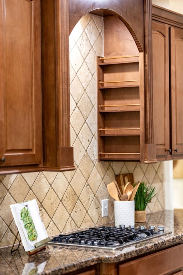 kitchen featuring decorative backsplash, brown cabinetry, and stainless steel gas stovetop