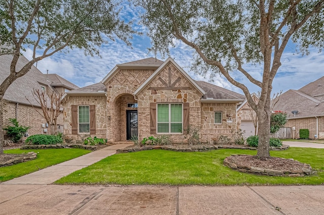 3215 Wimberly Place Ln, Katy, TX 77494 - view of front of house featuring a front yard, stone siding, brick siding, a shingled roof, and a garage