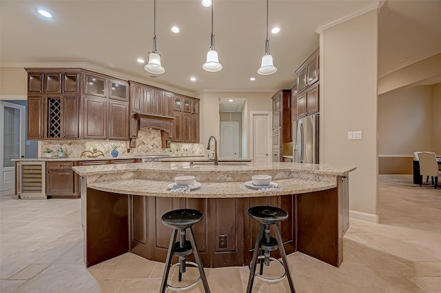 3215 Wimberly Place Ln, Katy, TX 77494 - kitchen with beverage cooler, a sink, tasteful backsplash, a breakfast bar area, and a large island