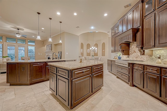 3215 Wimberly Place Ln, Katy, TX 77494 - kitchen featuring a kitchen island, arched walkways, stainless steel gas stovetop, ceiling fan, and recessed lighting