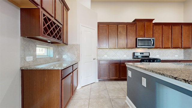 2135 Llerena Ln, League City, TX 77573 - kitchen featuring appliances with stainless steel finishes, light stone countertops, and tasteful backsplash