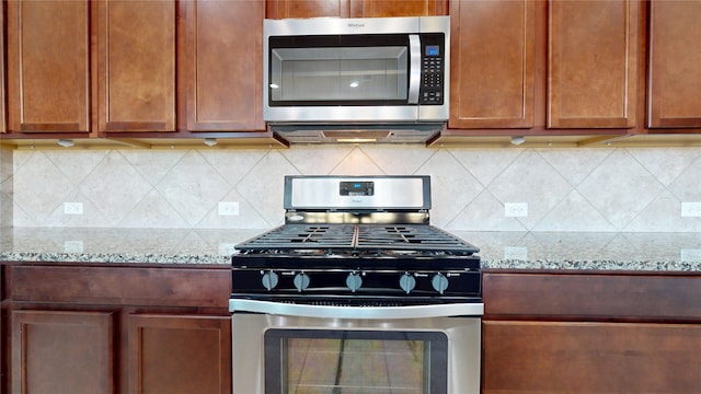 2135 Llerena Ln, League City, TX 77573 - kitchen with appliances with stainless steel finishes, light stone countertops, and backsplash