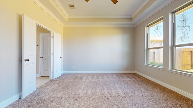 2135 Llerena Ln, League City, TX 77573 - empty room with light carpet, a raised ceiling, plenty of natural light, ornamental molding, and a ceiling fan