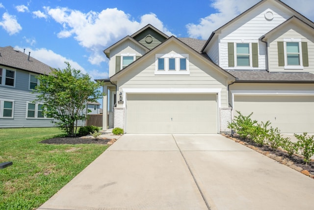 view of front facade with a garage, a front yard, brick siding, a shingled roof, and concrete driveway