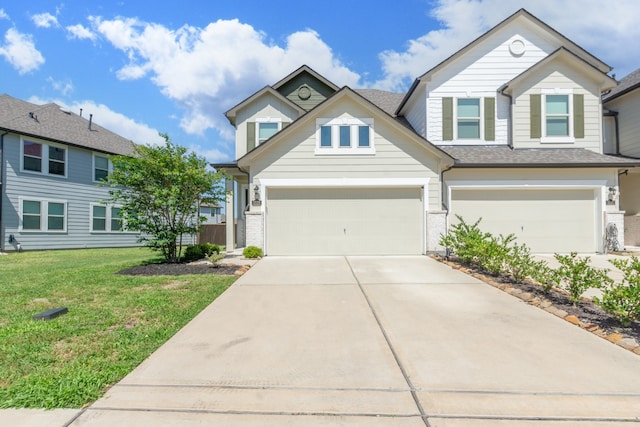 view of front of home featuring an attached garage, driveway, and a front yard